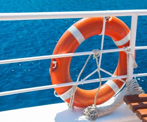 Red life buoy hanging on a boat. Help and support concept.