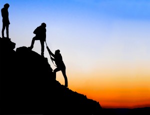 Silhouette of helping hand between two climber