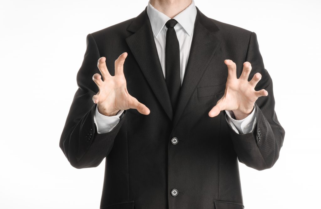 Businessman and gesture topic: a man in a black suit with a tie showing hands gesture on an isolated white background in studio